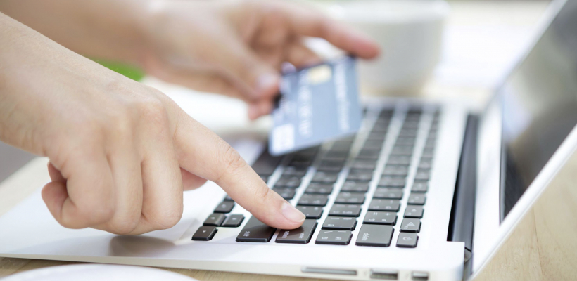 Hands holding a credit card and using laptop computer for online shopping