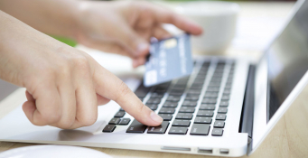 Hands holding a credit card and using laptop computer for online shopping